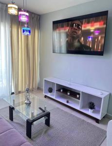 - un salon avec une grande télévision murale dans l'établissement BOvibe Condo - 2 Suites avec Piscine - Pueblo Bávaro, à Punta Cana