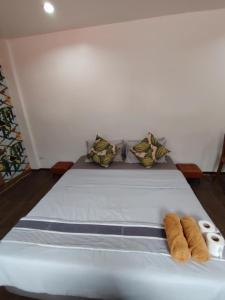 a bed in a room with two rolls of towels at Corner Crib El Nido Hostel in El Nido