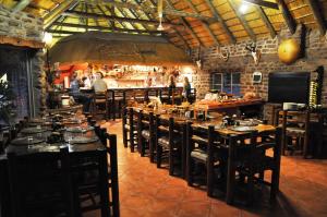 a restaurant with tables and chairs and people in a room at Outeniqua Guest Farm in Okahandja