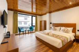 a bedroom with a bed and a desk and a television at Mystique Valley by Trekocity in Lachung