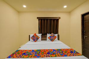 a bedroom with a bed with colorful pillows at Hotel Abhimanyu Villa in Hyderabad