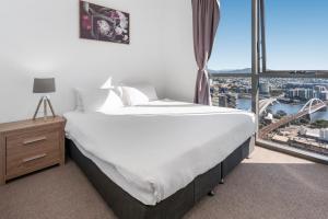 a bedroom with a large bed and a large window at River-View Unit with Rooftop Pool near Museums in Brisbane