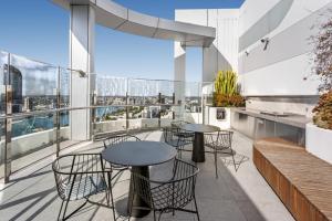 a balcony with tables and chairs on a building at River-View Unit with Rooftop Pool near Museums in Brisbane