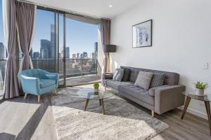 a living room with a couch and a large window at River-View Unit with Rooftop Pool near Museums in Brisbane