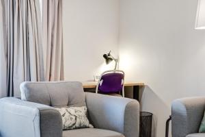 a living room with a couch and a chair and a desk at Central 2-bed Apartment with Gym and Spa in Canberra