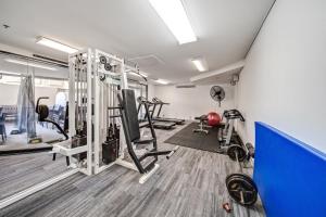 une salle de sport avec des tapis de course et des machines dans une pièce dans l'établissement Central 2-bed Apartment with Pool, Gym and Spa, à Canberra