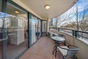 d'un balcon avec des chaises, une table et quelques fenêtres. dans l'établissement Central 2-bed Apartment with Pool, Gym and Spa, à Canberra