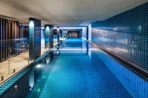 a swimming pool in a building with blue tiles at Chic 3-Bed in Central with Pool, Sauna and Gym in Canberra