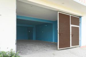 a large garage with a door in a building at Collection O Rajgir Railway Junction Formerly Hotel Mamta Kutir in Rājgīr