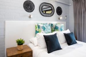 Cette chambre comprend un canapé blanc avec des oreillers et un miroir. dans l'établissement Batemans Bay Studio Escape with Lush Vista, à Batehaven