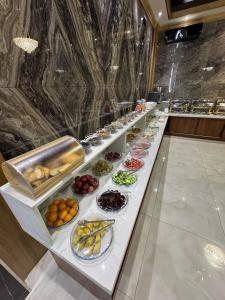 Una línea de buffet con muchos tipos diferentes de comida. en Hotel Elegant, en Andizhan