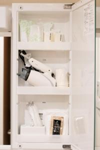 ein weißer Schrank voller Geschirr und Küchenutensilien in der Unterkunft Hotel S-Presso West - Vacation STAY 9086 in Osaka