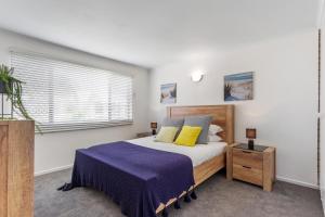 Un dormitorio con una cama y una ventana en Cosy 2-Bedroom Seaside Unit Steps from Beach, en Maroochydore