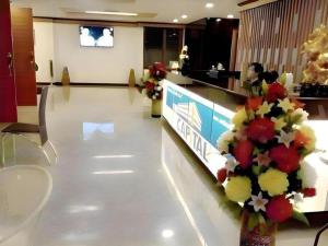 eine Lobby mit einer Empfangstheke mit Blumen darauf in der Unterkunft The Capital Hotel in Roi Et