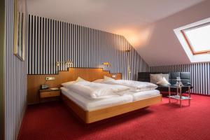 a bedroom with two beds and a red carpet at Hotel Restaurant Vinothek LAMM in Bad Herrenalb