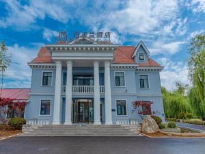 un grand bâtiment blanc avec un toit rouge dans l'établissement Magnotel Business Qufu Sankong Scenic Area Chunqiu West Road, à Qufu