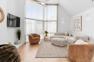 ein Wohnzimmer mit einer Couch und einem Sessel in der Unterkunft The Tides - Luxe Beach House Mornington in Mornington