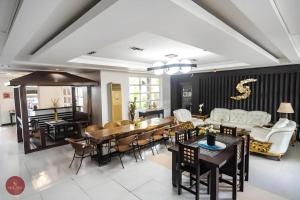 ein Esszimmer und ein Wohnzimmer mit Tisch und Stühlen in der Unterkunft Quezon Premier Hotel - Candelaria in Candelaria
