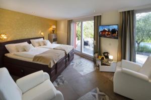 a bedroom with a bed and two chairs and a tv at Boutique Hotel Albergo Brione in Locarno +51 photos