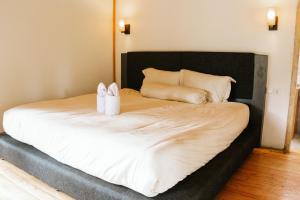 a bed with two white towels and pillows on it at The Good House in Gili Air