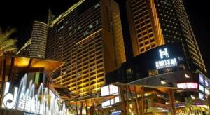 un bâtiment avec une enseigne d'hôtel devant quelques grands immeubles dans l'établissement Nanning Champs Elysees Hotel, à Nanning