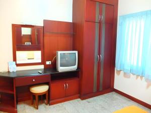 Cette chambre dispose d'un bureau, d'une télévision et d'un miroir. dans l'établissement Picnic Sriracha Hotel, à Ban Fang Daeng