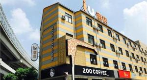 a yellow building with a zoco coffee sign on it at IU Hotel Shanghai Jiaotong University Jiangchuan Road Metro Station in Songjiang