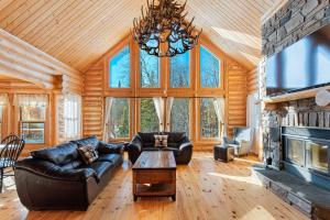 a living room with a couch and a fireplace at Fiddler Lake Resort - Deer 9 in Mille-Isles