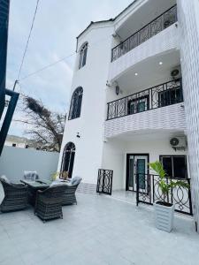 Un edificio blanco con sillas delante. en Serenity Apartments, en Old Yundum