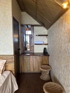 a small room with a bed and two stools at Elim Retreat kanthalloor in Kanthalloor