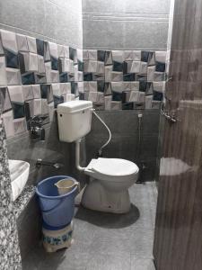 a bathroom with a toilet and a bucket at Hotel New Sun and Rock in Mount Ābu