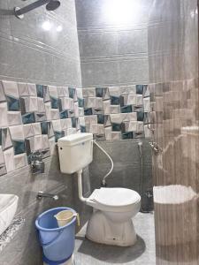 baño con aseo y cubo azul en Hotel SNR, en Mount Abu