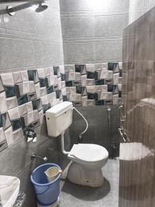 baño con aseo y cubo azul en Hotel SNR, en Mount Abu