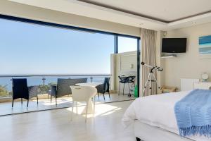 Un dormitorio con una cama y un balcón con vistas. en Sea Mount, en Ciudad del Cabo 144 fotos más