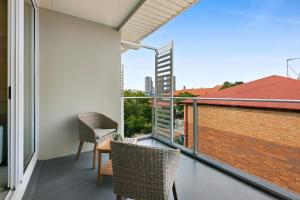 Un balcón con dos sillas y una mesa en un edificio. en Sleek Apartment with Pool and Rooftop Terrace, en Gold Coast 7 fotos más
