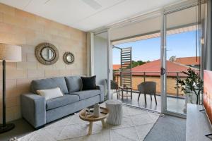 Una sala de estar con un sofá y un balcón. en Sleek Apartment with Pool and Rooftop Terrace, en Gold Coast