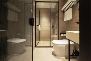 a bathroom with a toilet and a glass shower at Hanting Hotel Shanghai Xujiahui Jiaotong University Yishan Road in Shanghai +19 photos
