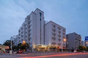 a large white building on a city street at night at Jinjiang Inn Select Xuzhou Suning Plaza Jinguang East Road in Xuzhou