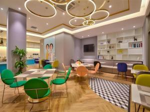 ein Wartezimmer mit bunten Stühlen und Tischen in der Unterkunft Magnotel Ningbo Beilun Yintai City Xindalu in Ningbo