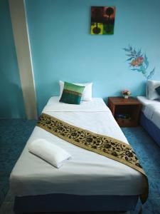 a bedroom with a large white bed with a long blanket at StayStable Guest House in Ko Lanta Yai