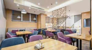 a dining room with tables and purple chairs at Borrman Hotel Fangchenggang High-speed Railway North Station Crystal International in Fangcheng