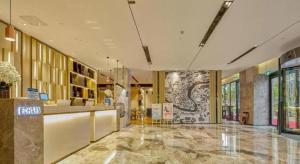 a lobby of a building with a marble floor at Echarm Hotel Liuzhou High-speed Railway Station in Liuzhou