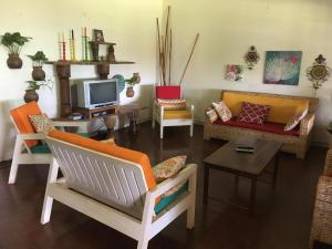 uma sala de estar cheia de mobiliário e uma televisão em Surjios Guest House em Jinja
