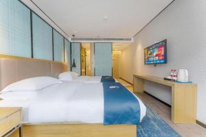 une chambre avec un grand lit et une télévision dans l'établissement Echarm Hotel Fuzhou Sanfang Qixiang East Street Metro Station, à Fuzhou