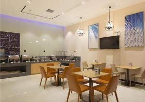 a restaurant with tables and chairs and a counter at City Comfort Inn Liuzhou High-speed Railway Station Entrance in Liuzhou