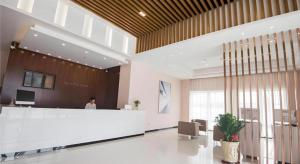 eine Lobby mit einer Person, die an der Rezeption steht in der Unterkunft City Comfort Inn Shantou Daxue Road in Shantou