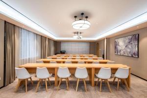 a conference room with a large wooden table and chairs at City Comfort Inn Xiantao Avenue Wangzhou Bridge Wushang in Xiantao