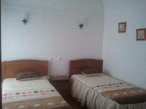 two beds in a room with white walls at A Casa in Portel