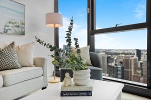 a living room with a couch and a table at Breathtaking City Views 1-Bed with Pool, BBQ & Gym in Brisbane
