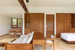 a bedroom with a couch and a bed and a table at Medewi Surf Villa Luxury in Airsatang +29 photos